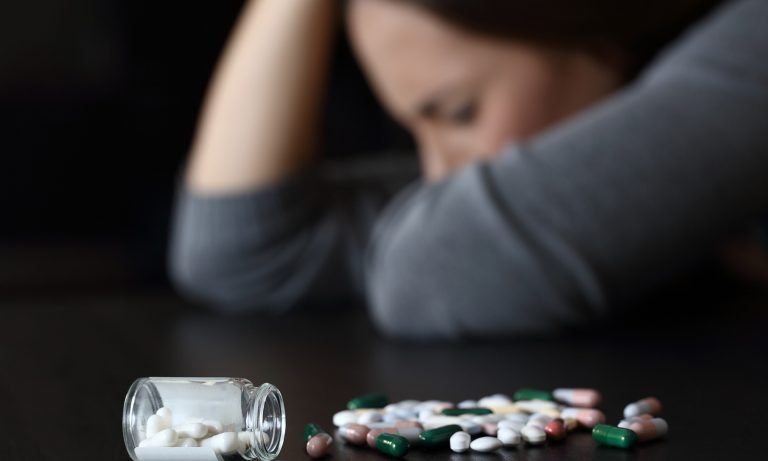 depressed-woman-beside-a-lot-of-pills-768