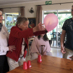 Joan England, helped by Val Tytreous, enjoys a fun activity in the company of her children, who were visiting from abroad.